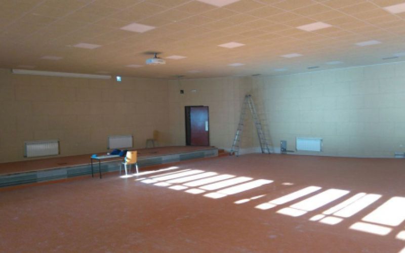 Imagen de sala grande con techo en obras con placas cuadradas